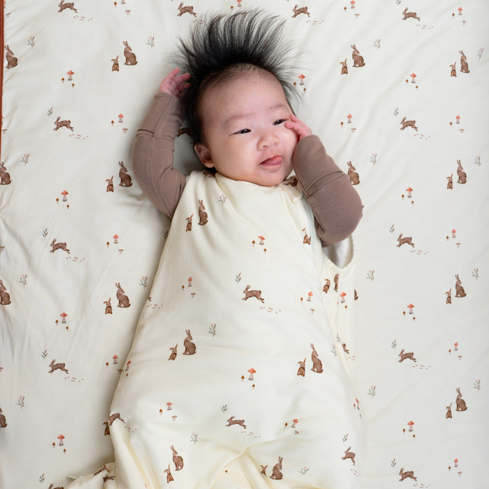 baby wearing quilted child blanket in bunnies print