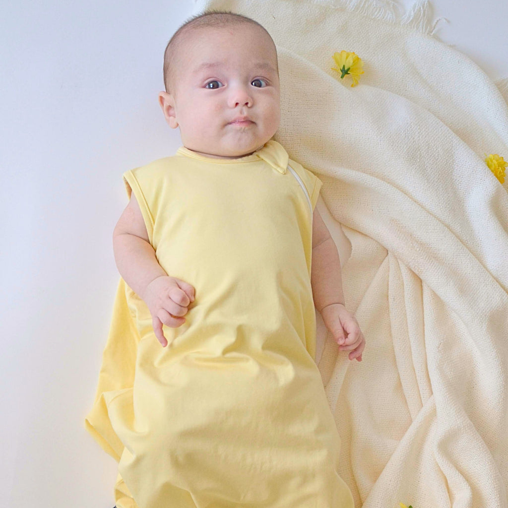 baby wearing sleep bag in mellow yellow solid color