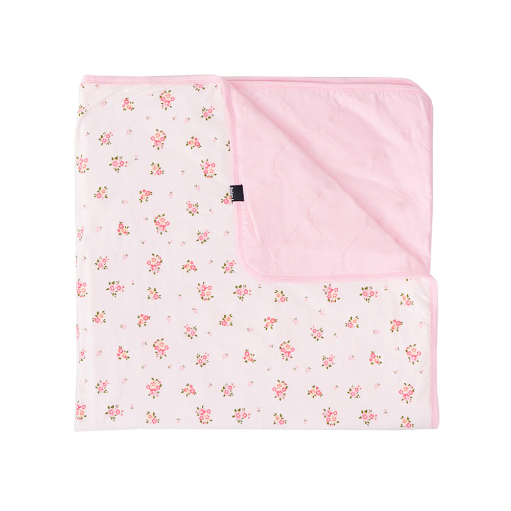 quilet child blanket in blushing blossom print, with light pink color inside