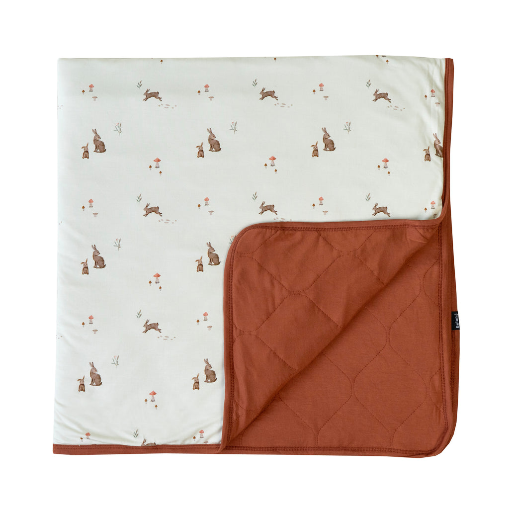 quilted child blanket in bunnies print, with toffee color inside