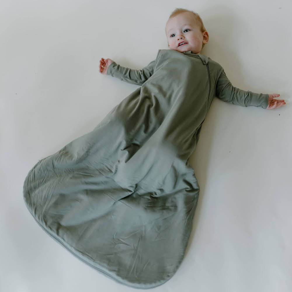 baby wearing sleep bag in moss solid color